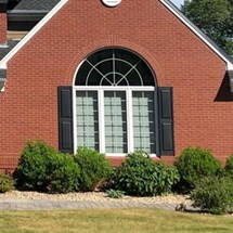 Fanlight arched window installed above triple window setup on Connecticut home