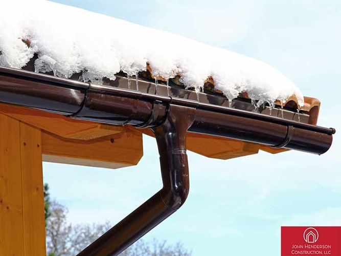 Snow and ice buildup on New England home's roof and gutters